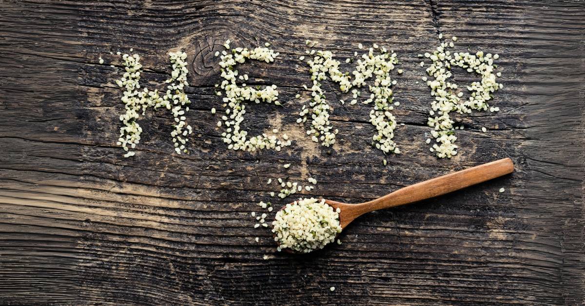 Hemp seeds on a wooden table spell out the word HEMP